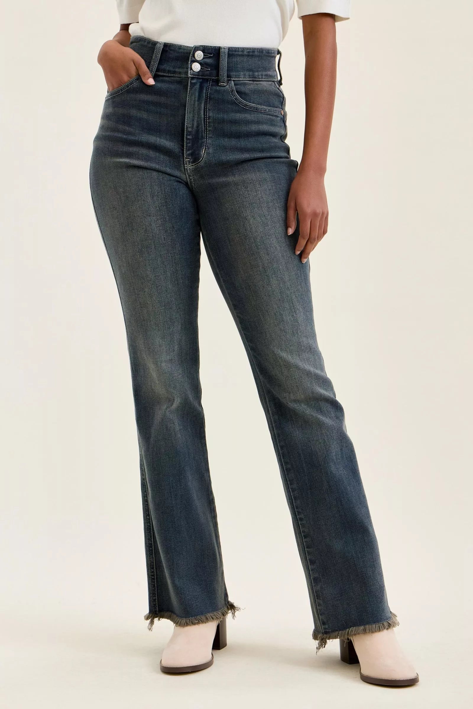 High-waist double-button jeans in dark denim with frayed ankle hem and front pockets.