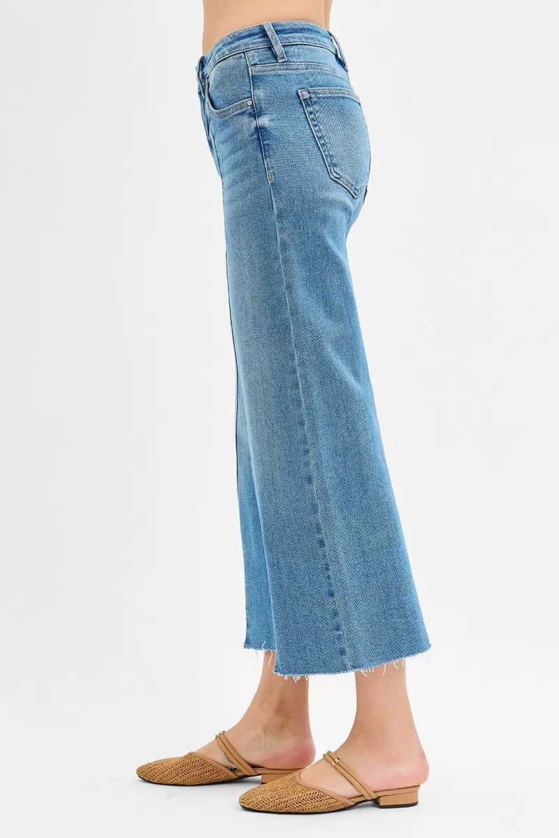Medium-wash side view: wide-leg cropped jeans with front slit and frayed hem