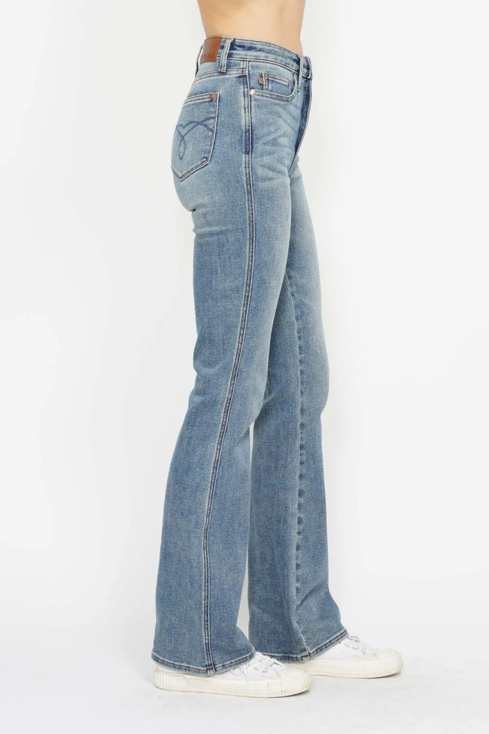 Back/side view: light blue bootcut jeans with embroidered back pocket accents