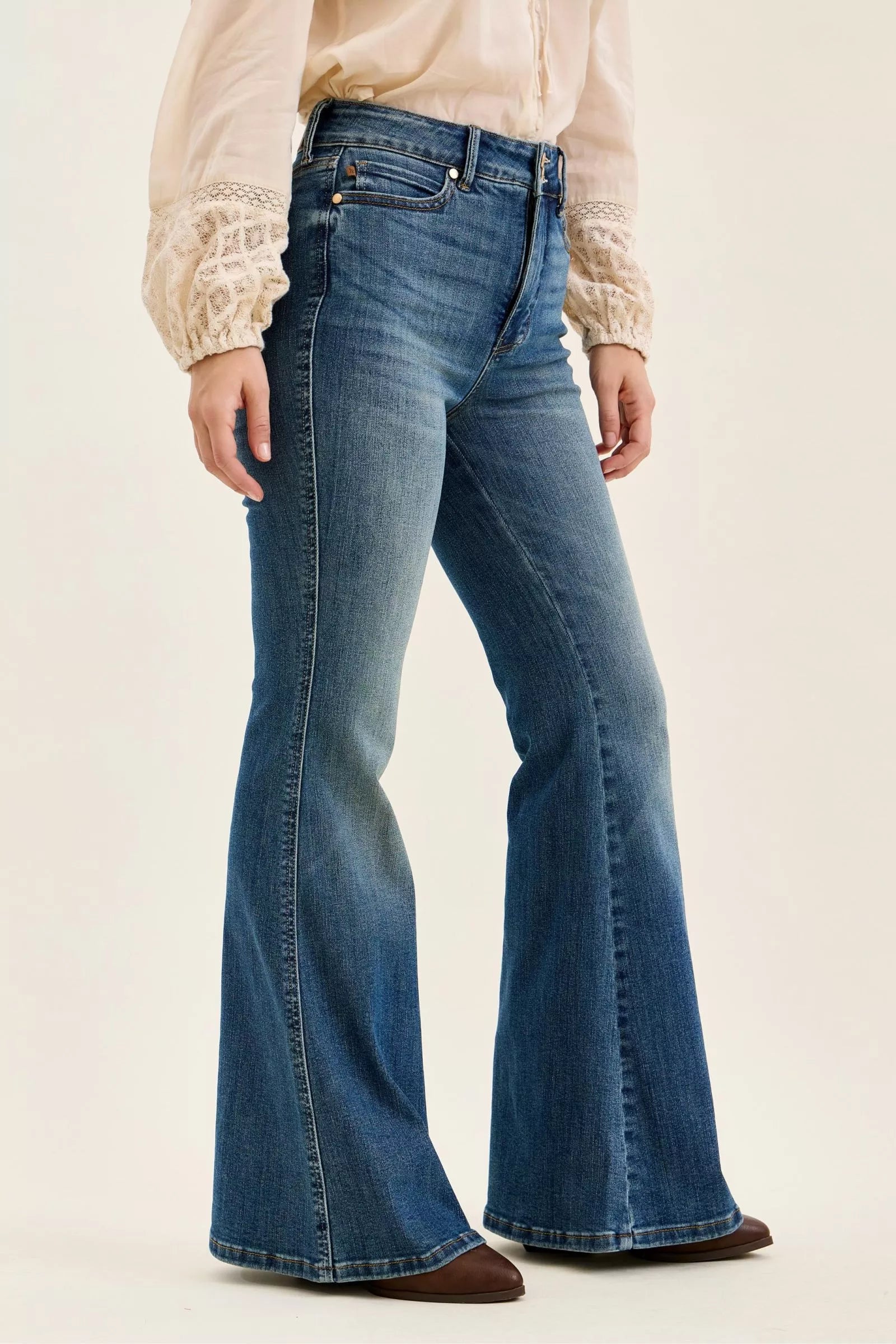 Dark denim high-waist flare jeans, side profile with long straight-to-flare leg