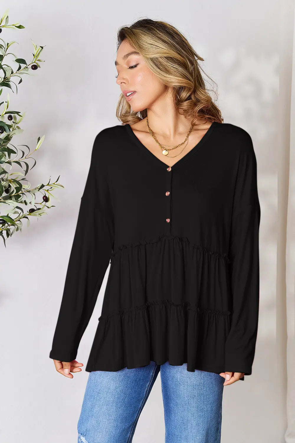 Black long-sleeve blouse with V-neck and half-button front, tiered ruffle hem