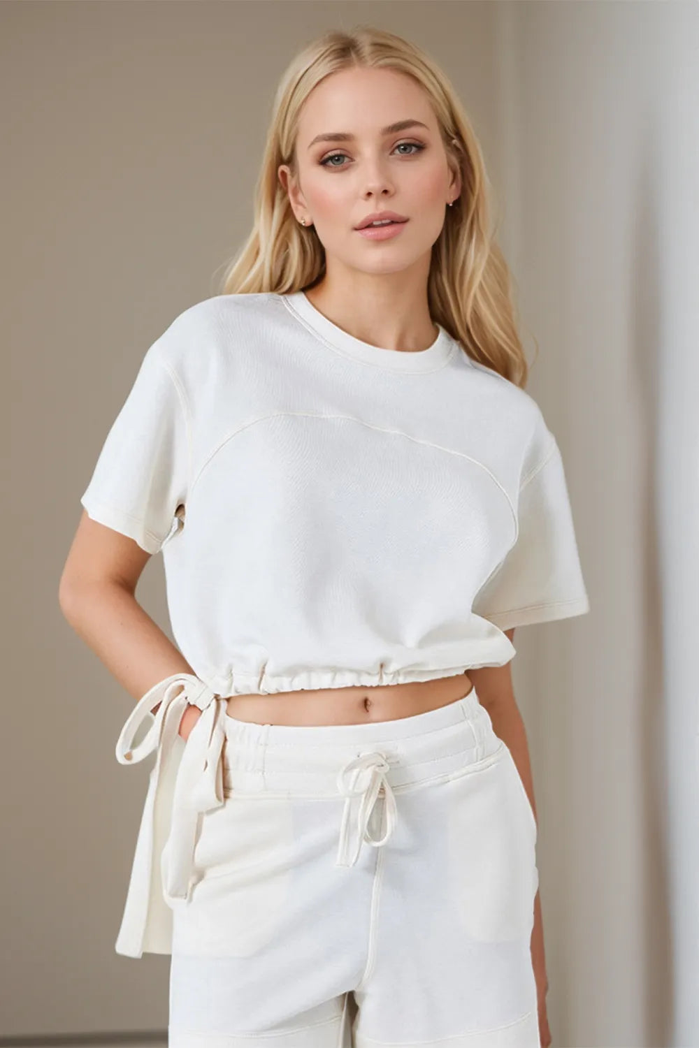 Cream cropped T-shirt with round neck and drawstring waist hem, side view