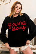 Black sweater with red “Game Day” lettering, crew neck and ribbed cuffs