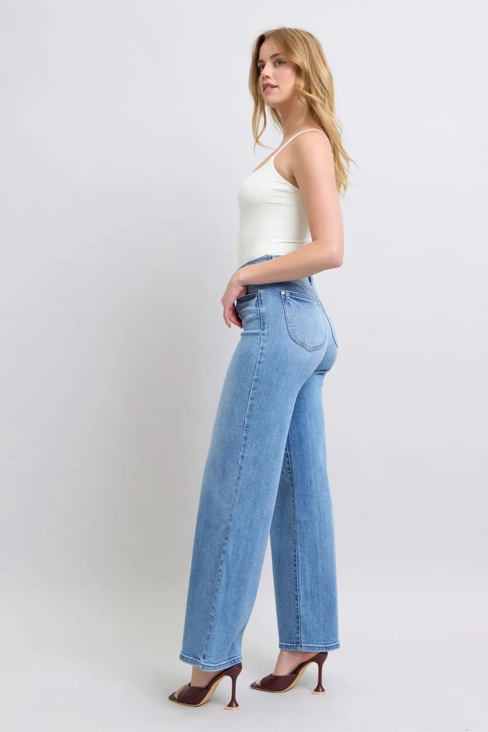 Medium-wash wide-leg jeans, side view with front pocket and belt loops