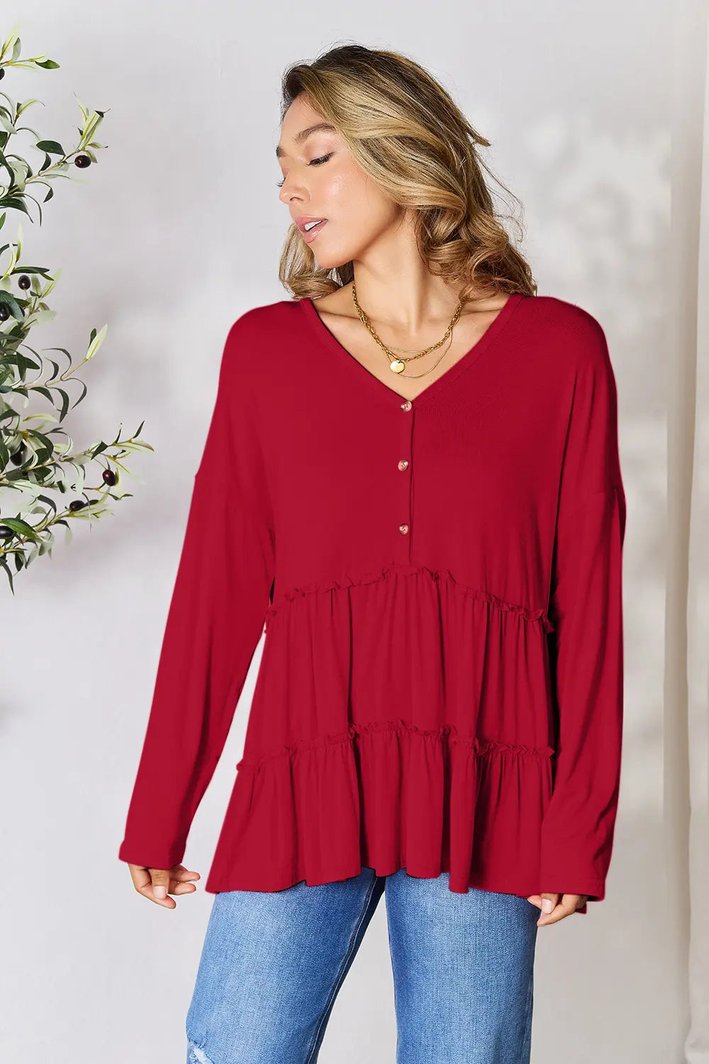 Burgundy blouse with V-neck half-button front, long sleeves, and tiered ruffle hem