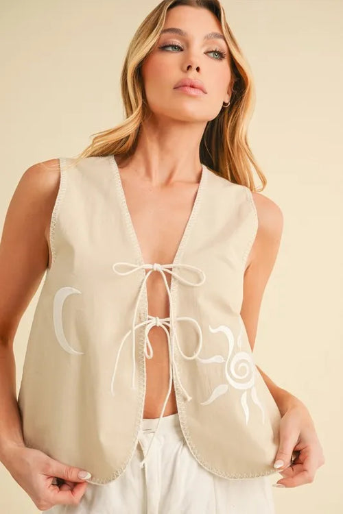 Sleeveless oat embroidered vest with front lace-up ties and swirl detailing