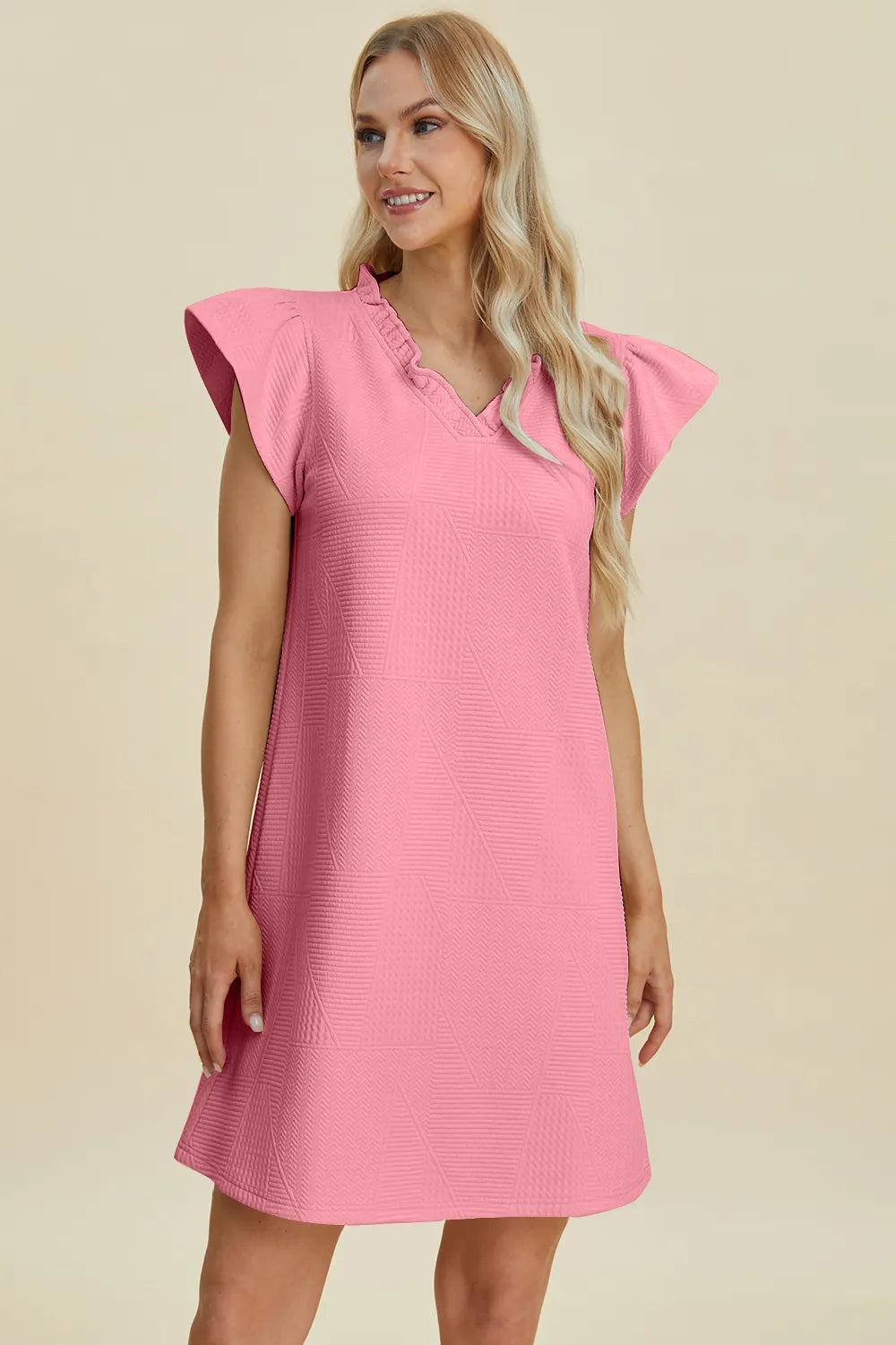 Pink V-neck cap-sleeve dress with ruffled neckline and textured geometric pattern