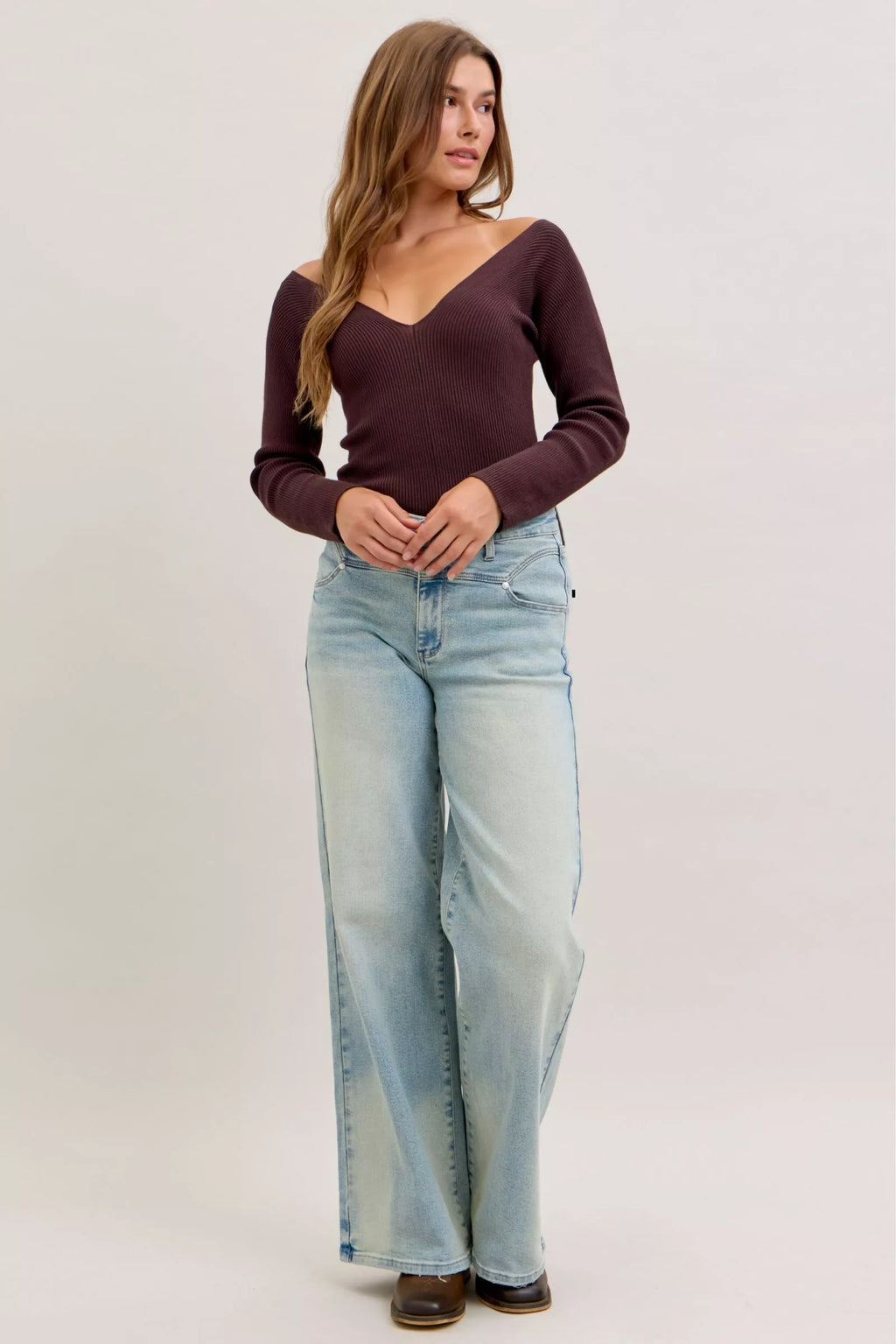 Light blue high-waist straight jeans on model, front view with whisker wash and rolled hem