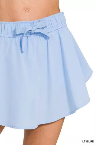 Light blue woven skort close-up: elastic waistband with drawstring ties