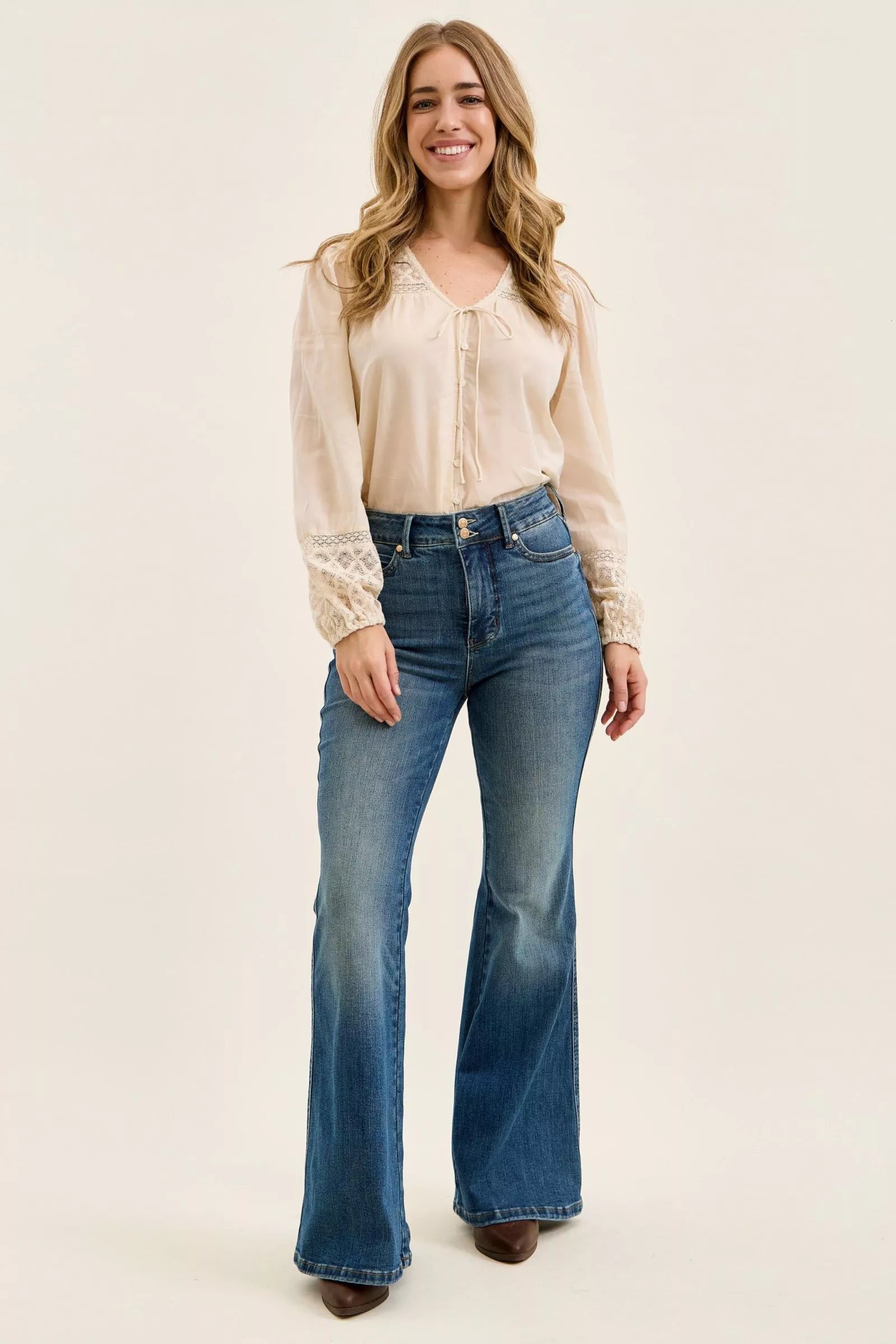 Dark denim high-waist flare jeans on model, straight fit through hips