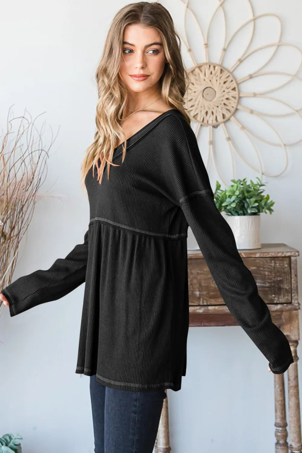 Black V-neck ribbed babydoll top, long sleeves; side view with flared hem