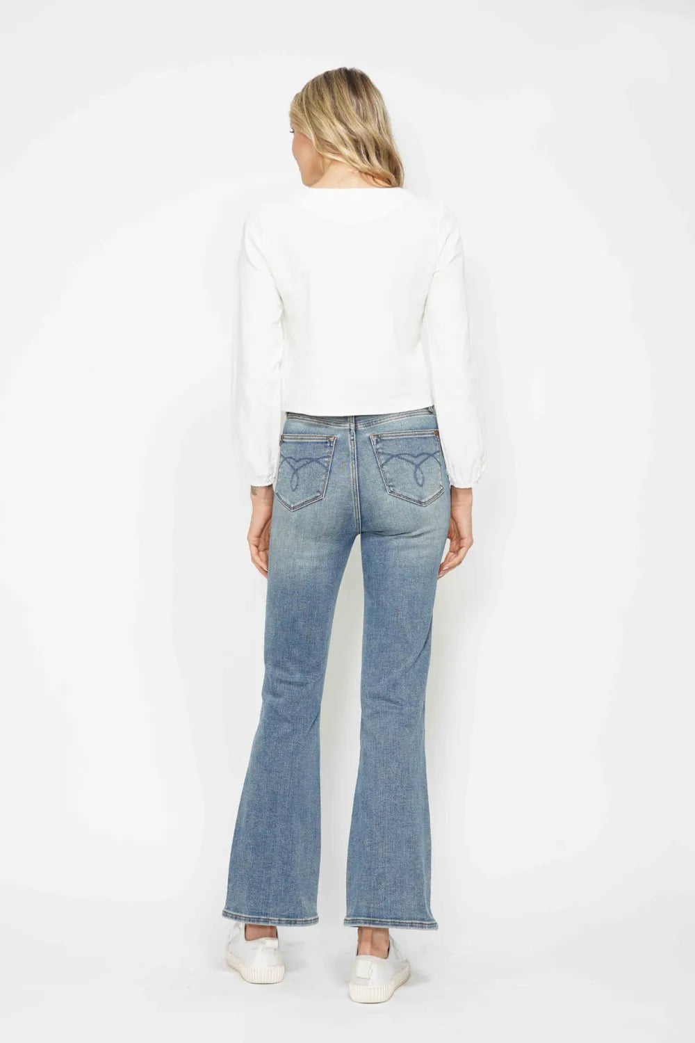 Light blue bootcut jeans, back view; embroidered back pockets and yoke seam