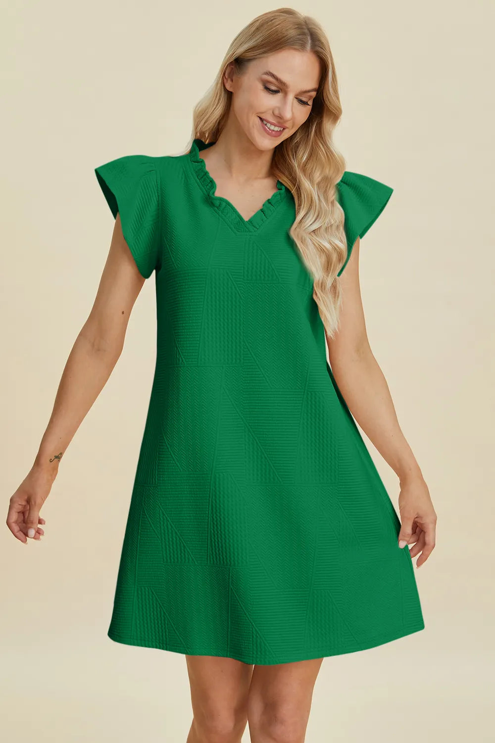 Ruffled V-neck cap sleeve dress in dark green, three-quarter front view with textured fabric.