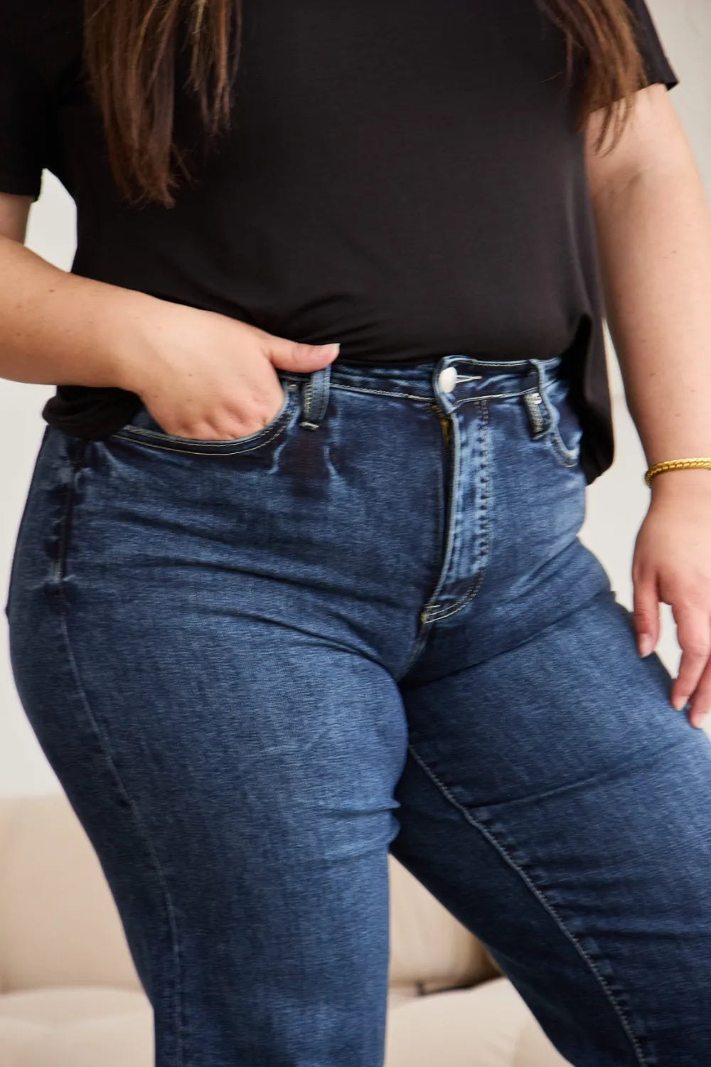 Close-up of high-waist jeans: button-front, belt loops, dark blue distressed wash