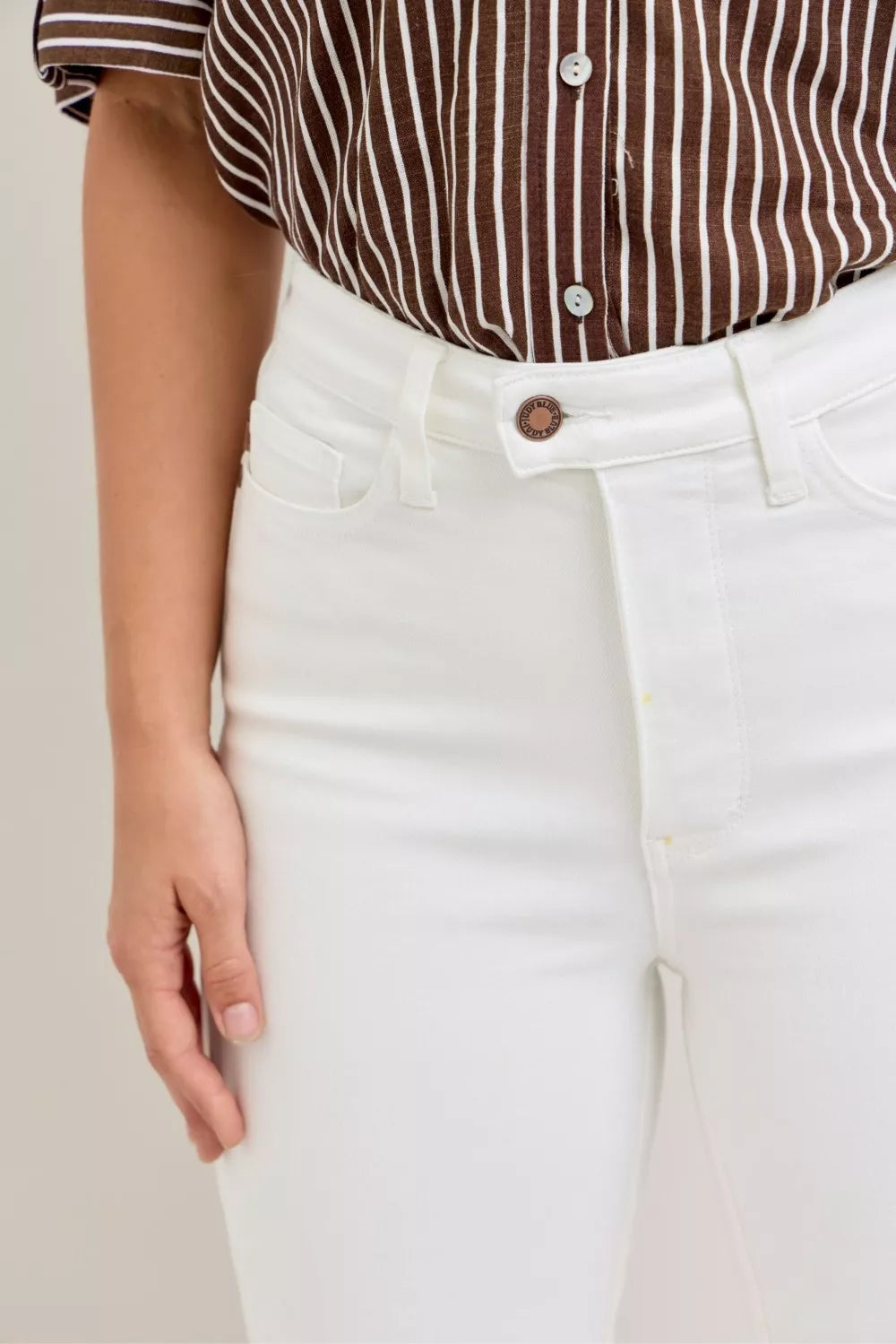 White high-waist capri jeans with button closure and spade pockets detail