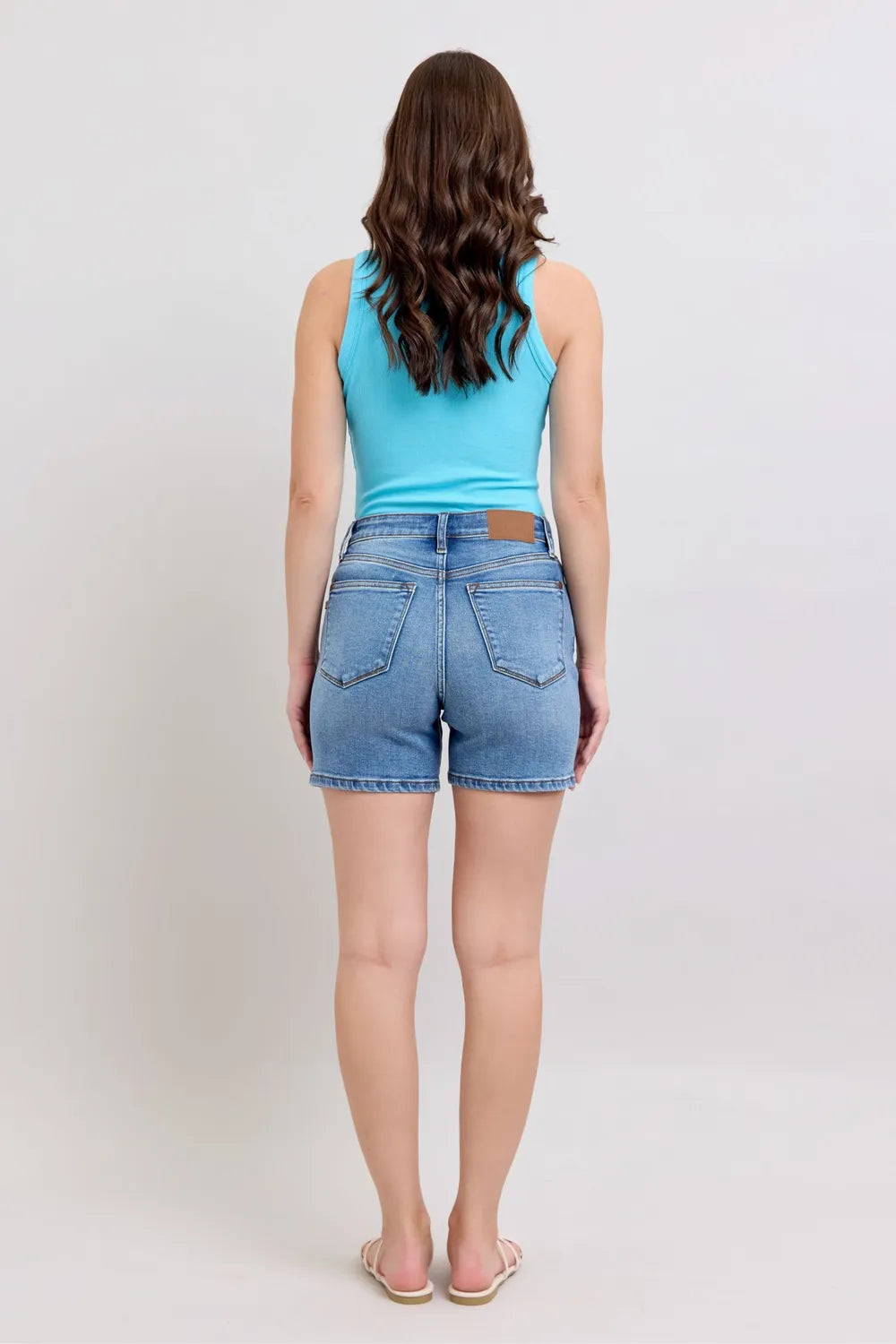 Back view: medium-wash denim shorts with two back pockets and belt loops