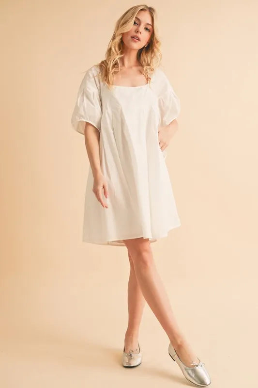 White square-neck babydoll dress with short puff sleeves and flared skirt