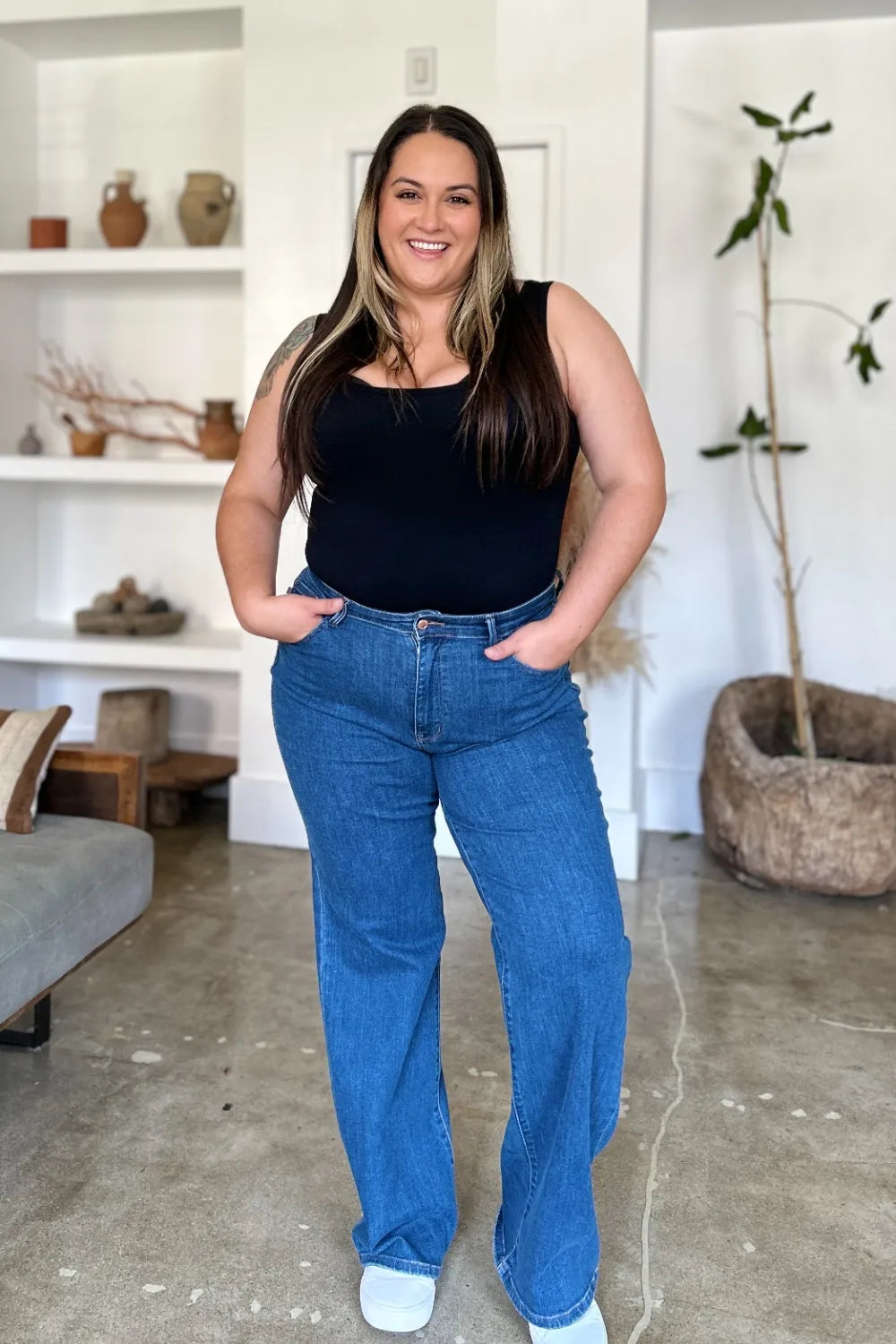 Medium blue high rise straight jeans with orange-brown button and five-pocket style