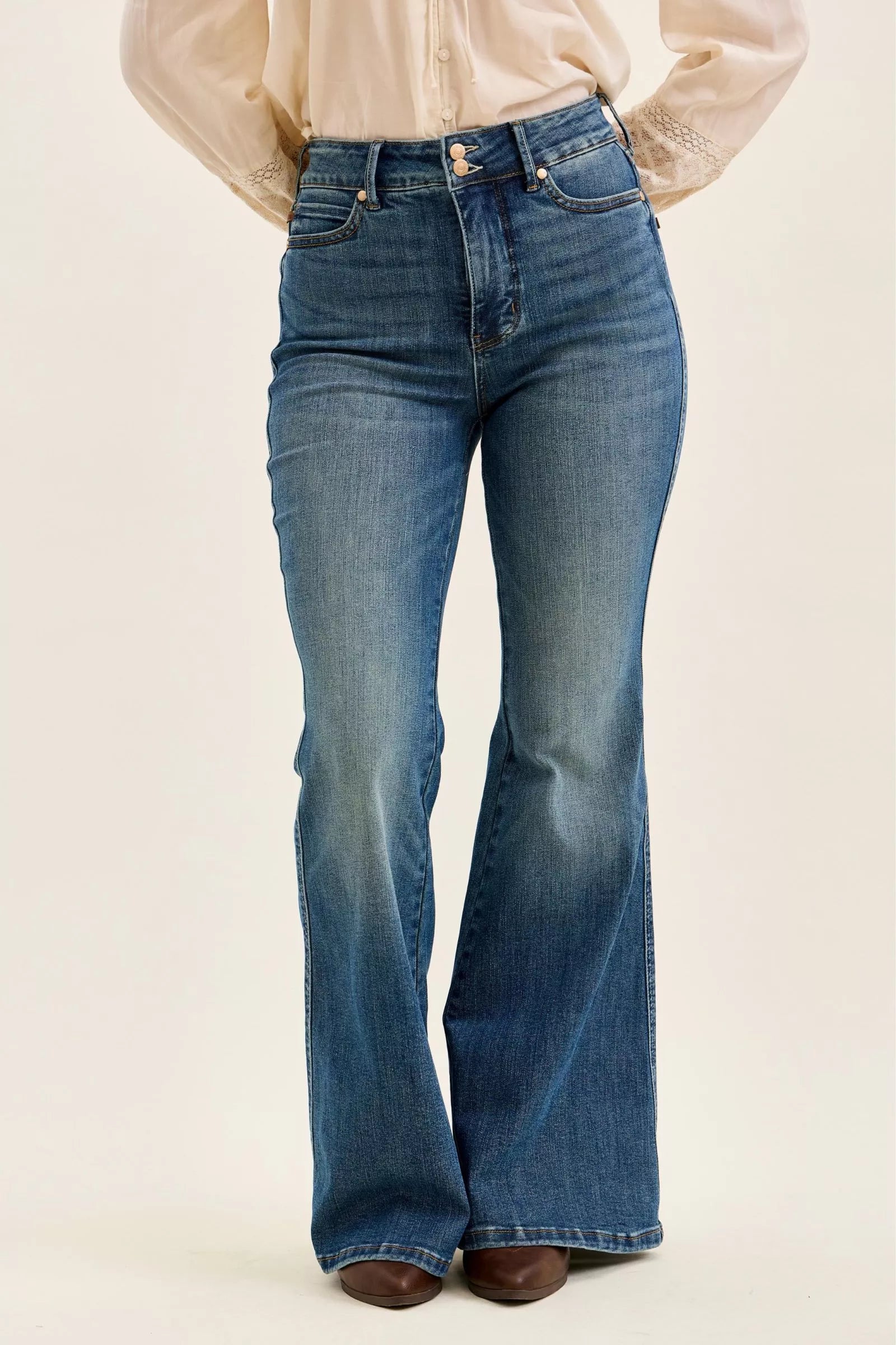 Dark denim high-waist flare jeans, front view with button and zip closure