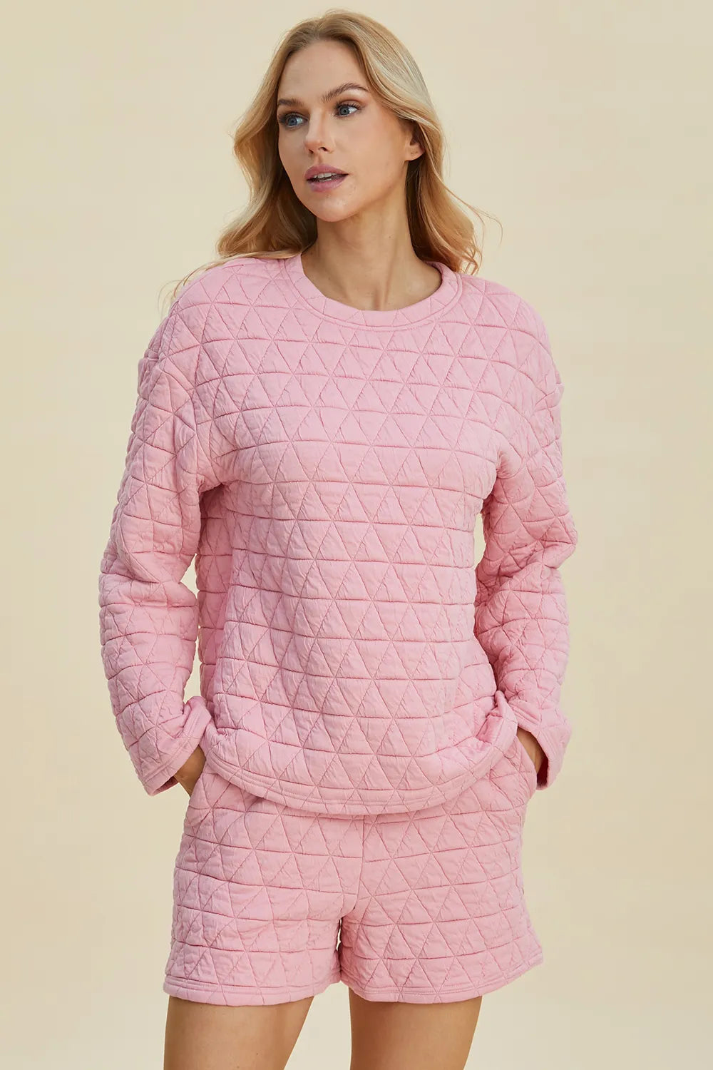 Pink quilted long-sleeve top and matching shorts set, round neck, geometric triangle pattern.