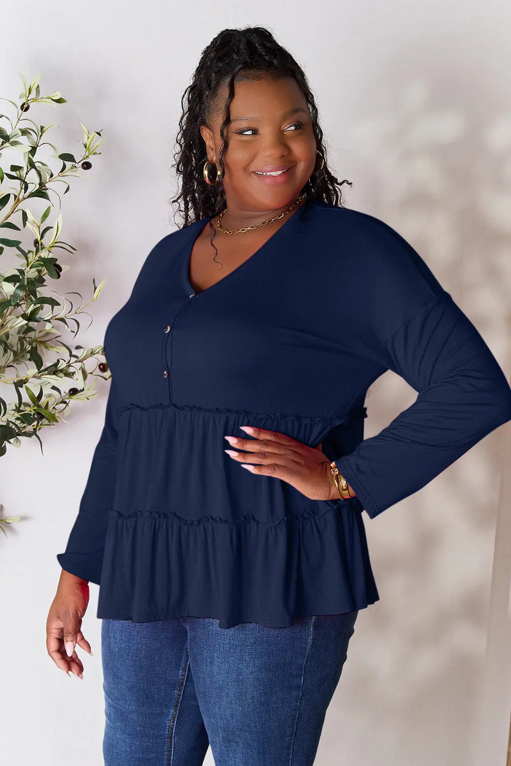 Dark blue long-sleeve blouse with V-neck half-button front and tiered ruffle hem