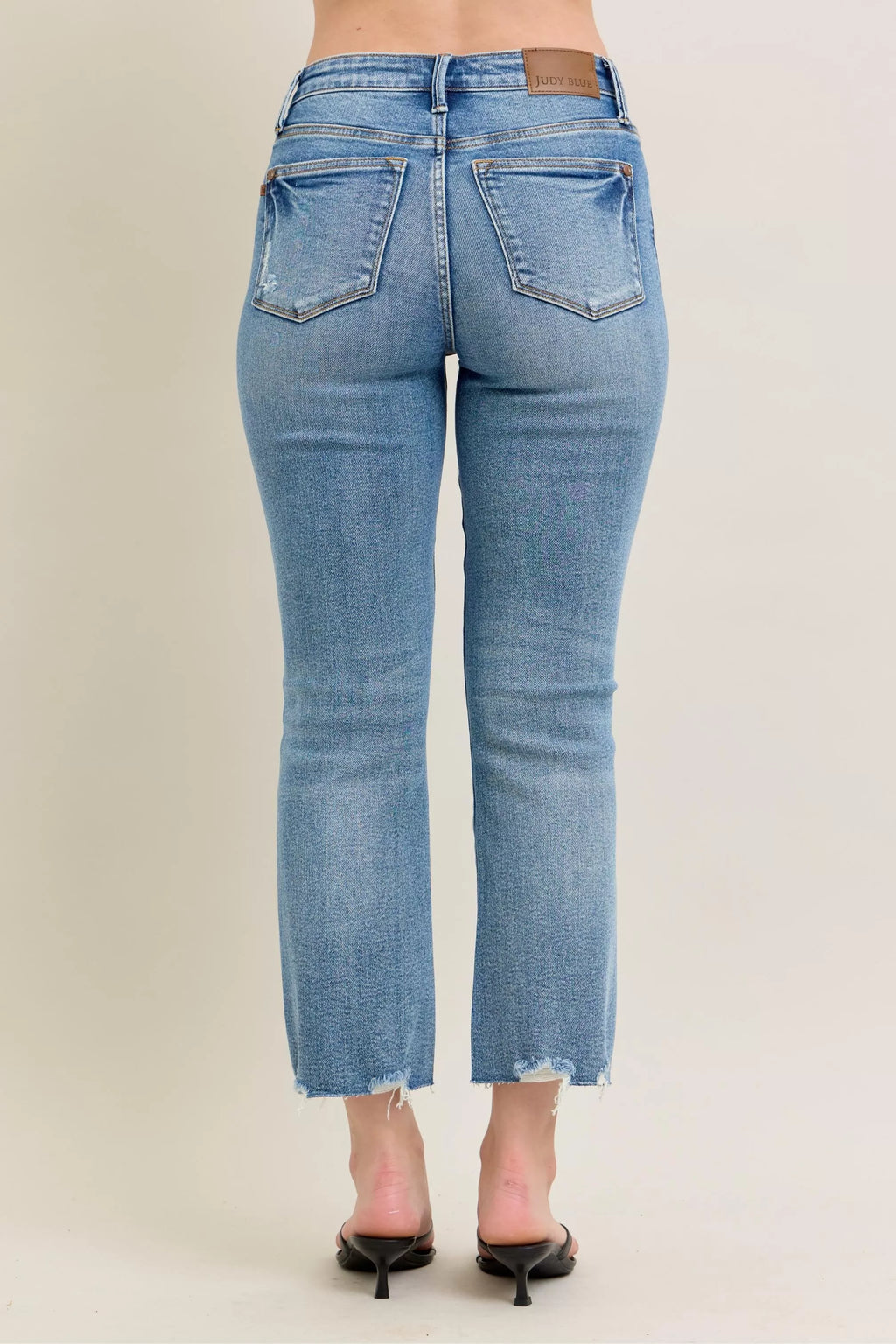 Medium-wash straight-to-kick flare jeans with back patch pockets and frayed hem