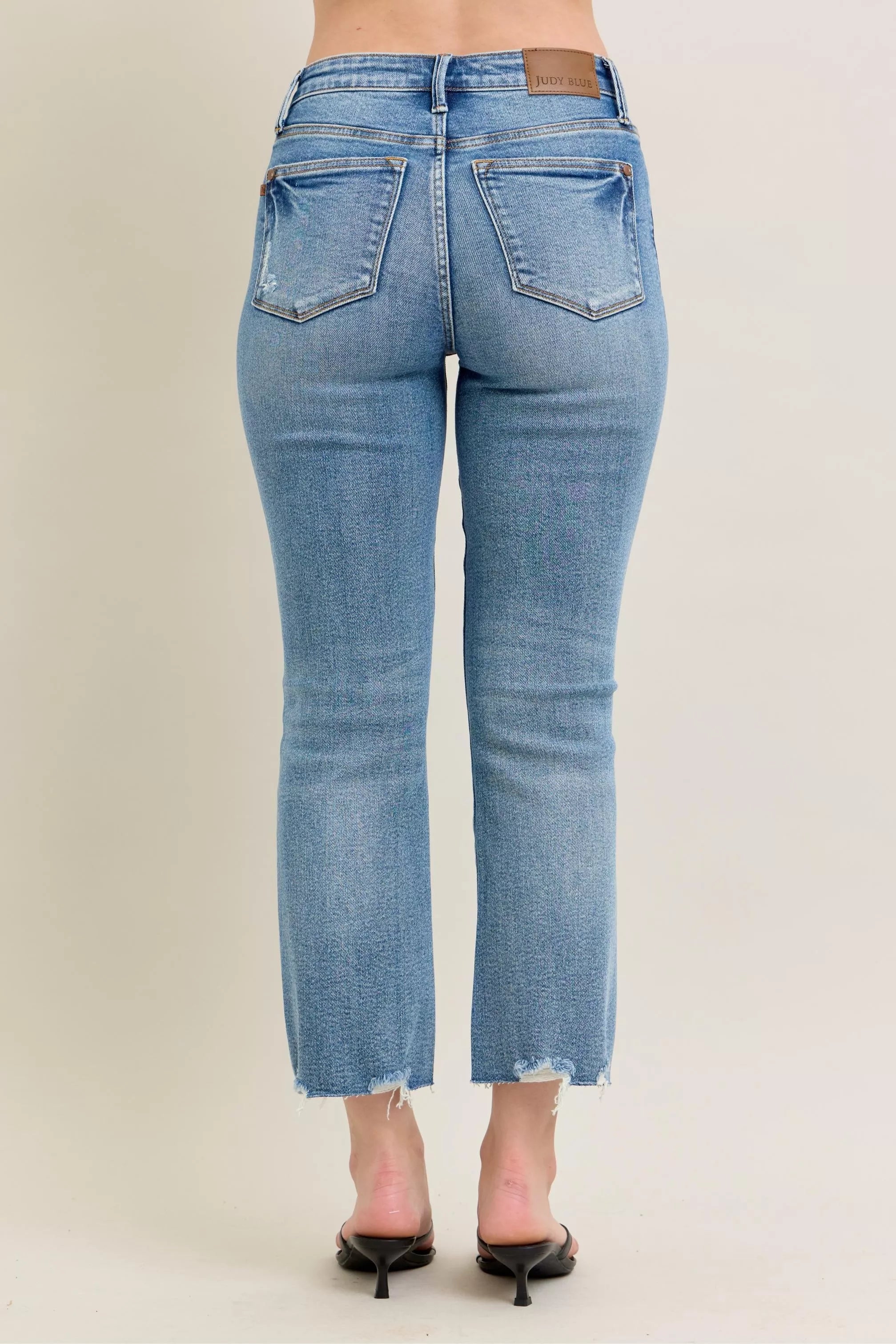 Medium-wash straight-to-kick flare jeans with back patch pockets and frayed hem