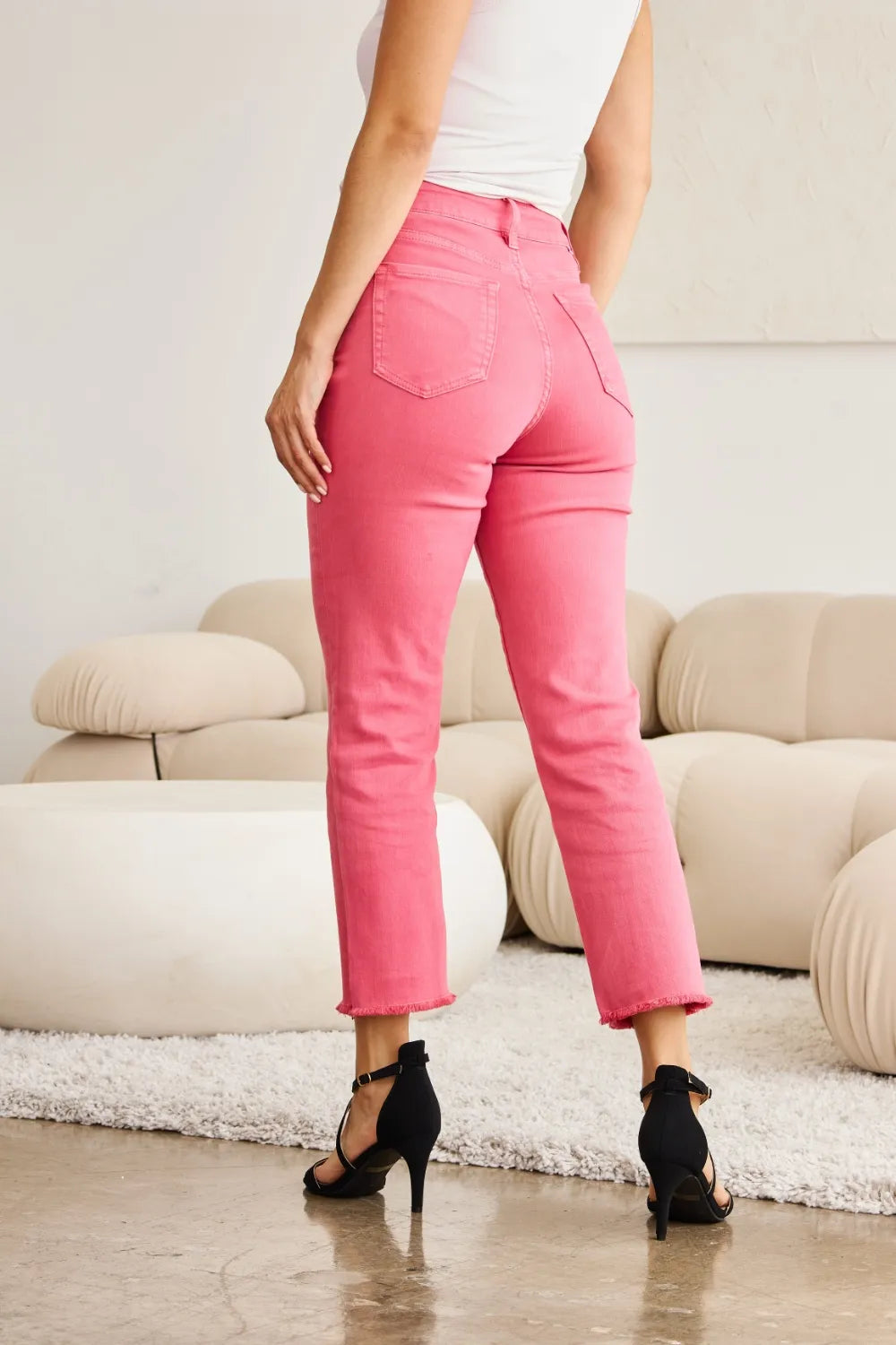 Sunkissed pink high-waist denim jeans with raw hem at the ankle