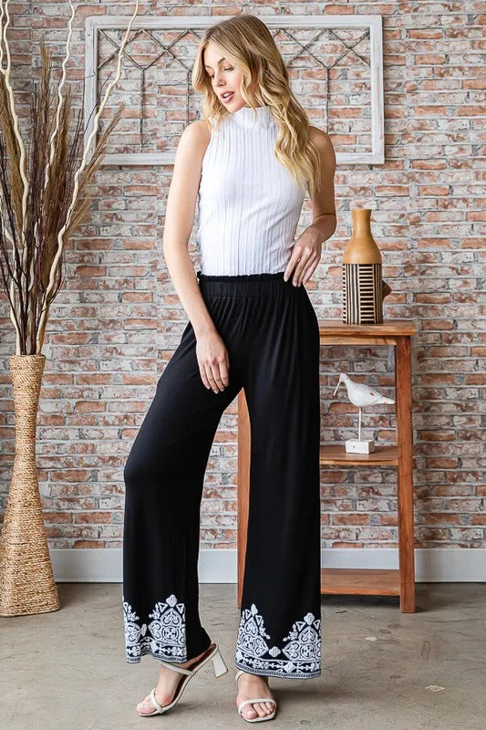 Black wide-leg pants with elastic pull-on waist and white damask hem border
