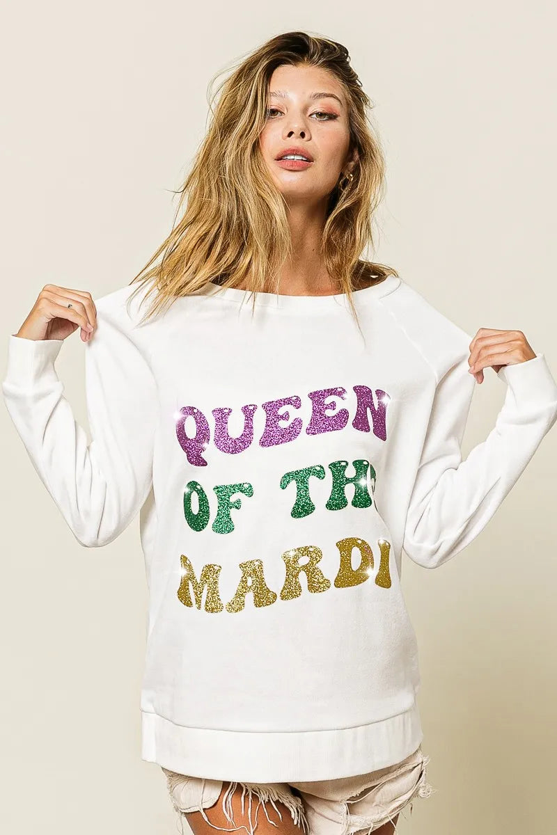 Off-white pullover sweatshirt with glitter text “QUEEN OF TH3 MARDI” across chest