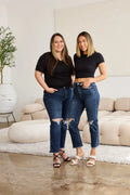 High-waist distressed jeans in dark blue with raw hem and knee rips
