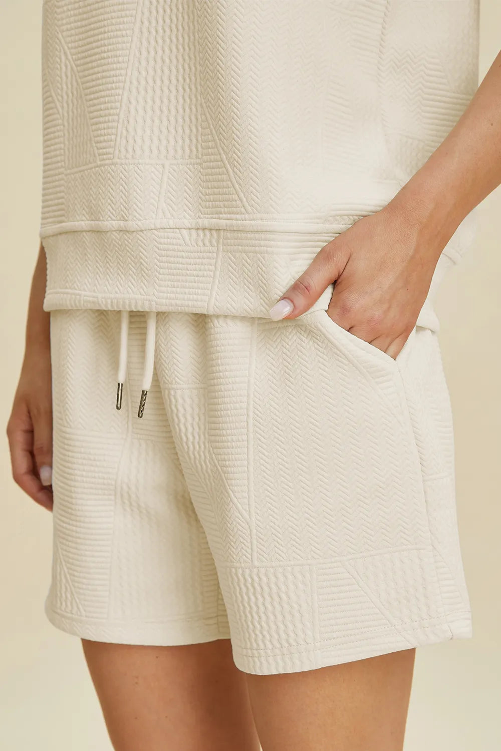 Cream textured drawstring shorts with elastic waistband and side seam details