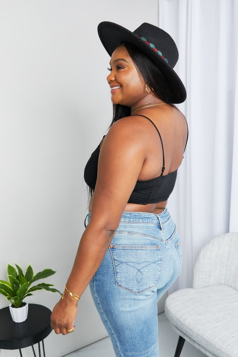 Black textured bralette viewed from the side with spaghetti straps and wide back band