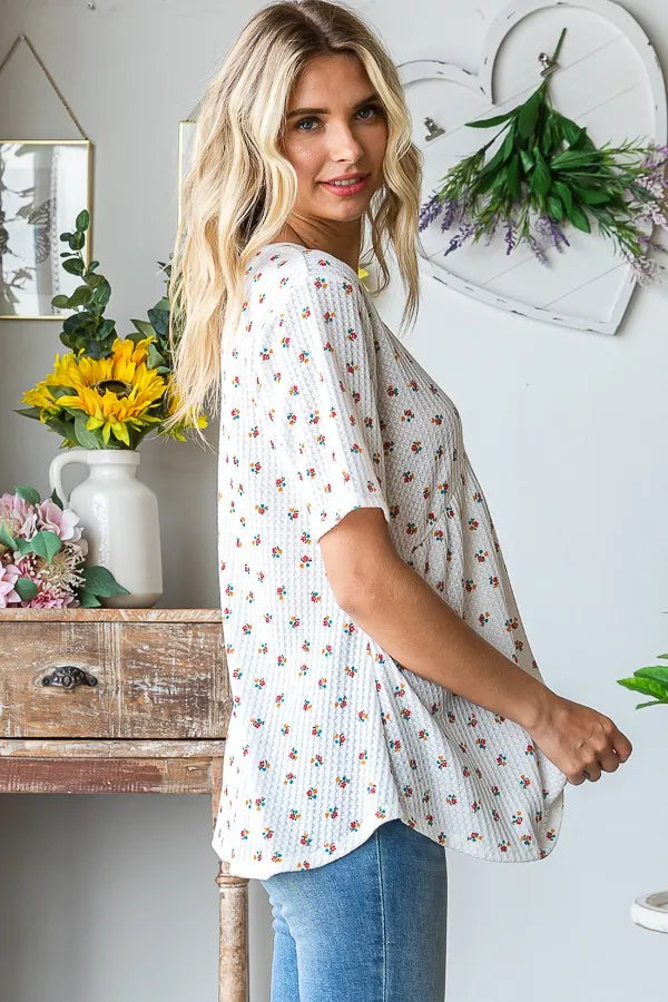 White ditsy floral babydoll top with crisscross V neckline and short flared sleeves
