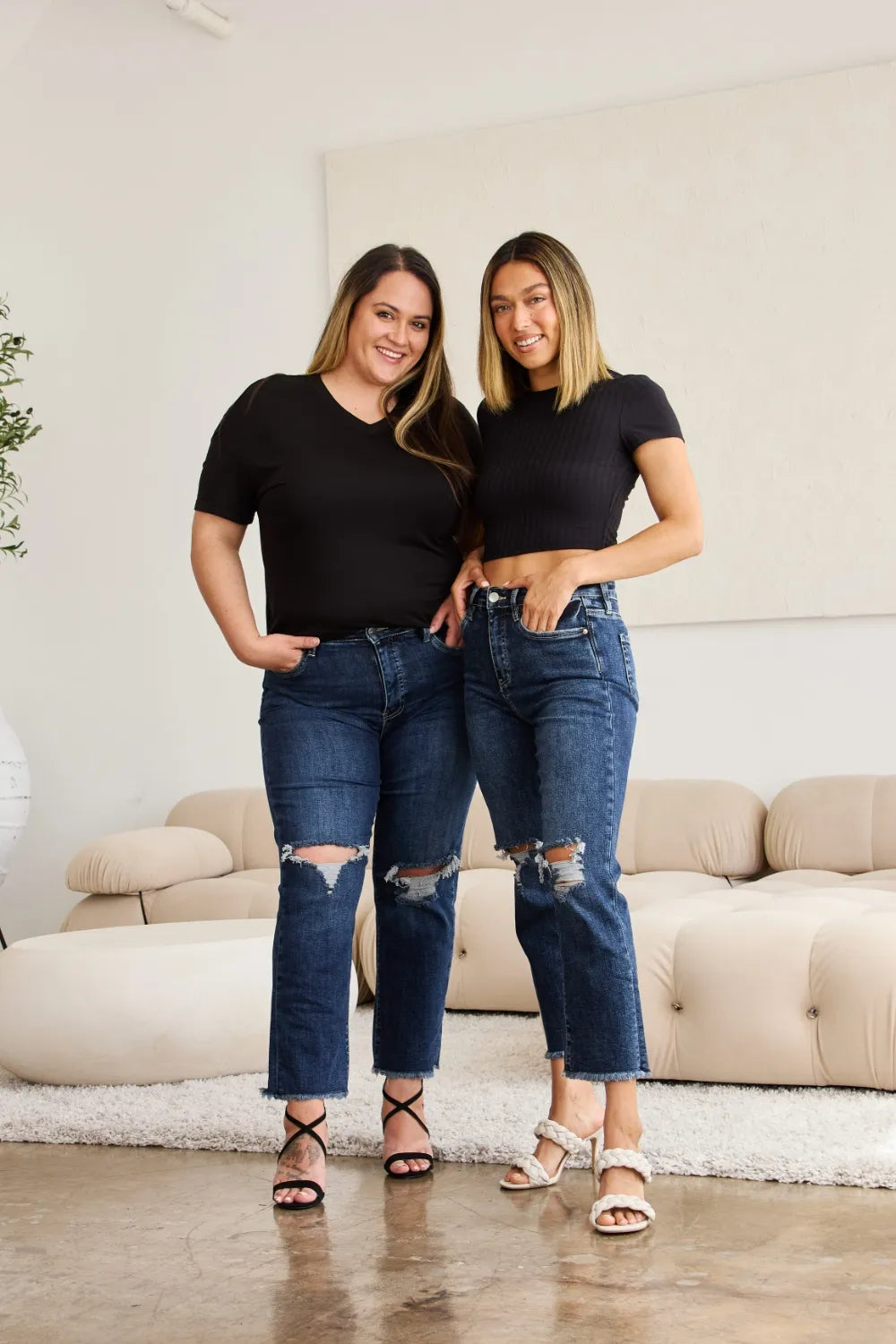 Distressed dark blue high-rise jeans with raw cuff hems and ripped knees