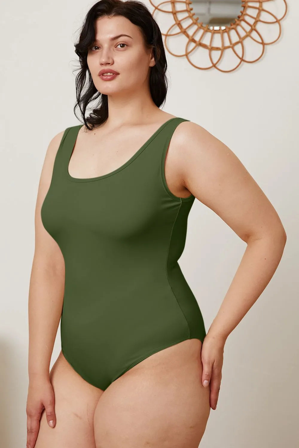 Dark green sleeveless bodysuit with scoop neckline, side view