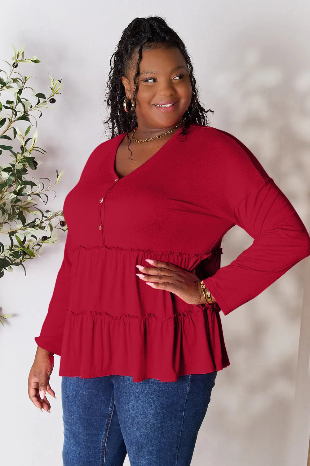 Burgundy long-sleeve V-neck blouse with half-button front and tiered ruffle hem