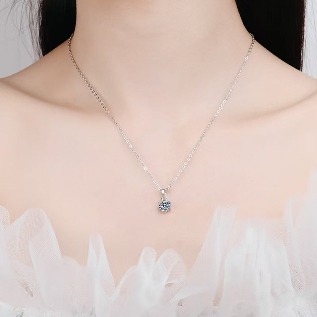Sterling silver moissanite pendant necklace worn on collarbone with small round stone