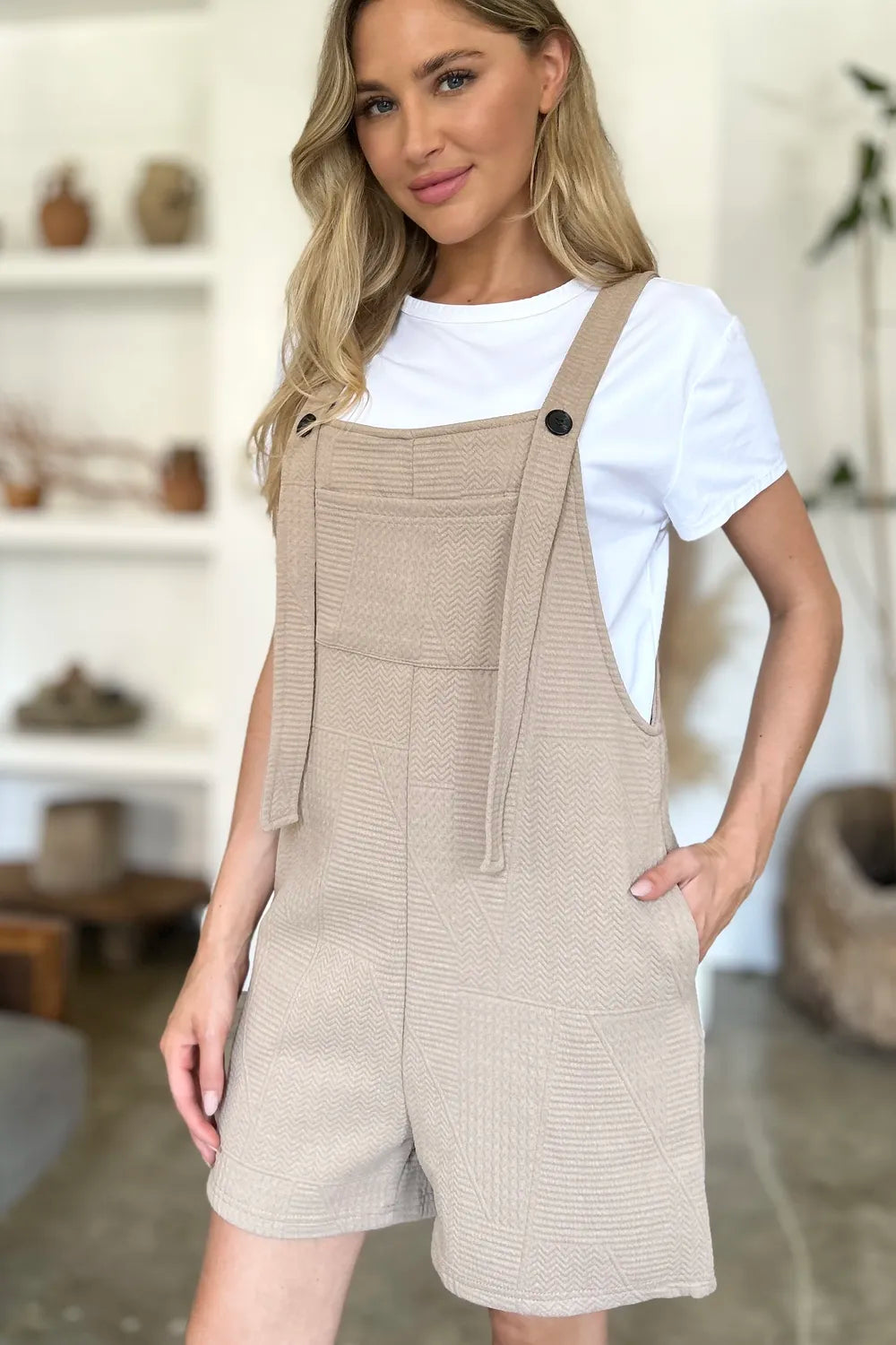 Khaki textured sleeveless romper with front seam detailing and side pockets