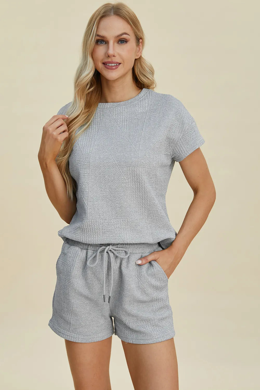 Cerulean blue short-sleeve textured top and drawstring shorts set, front view with hands
