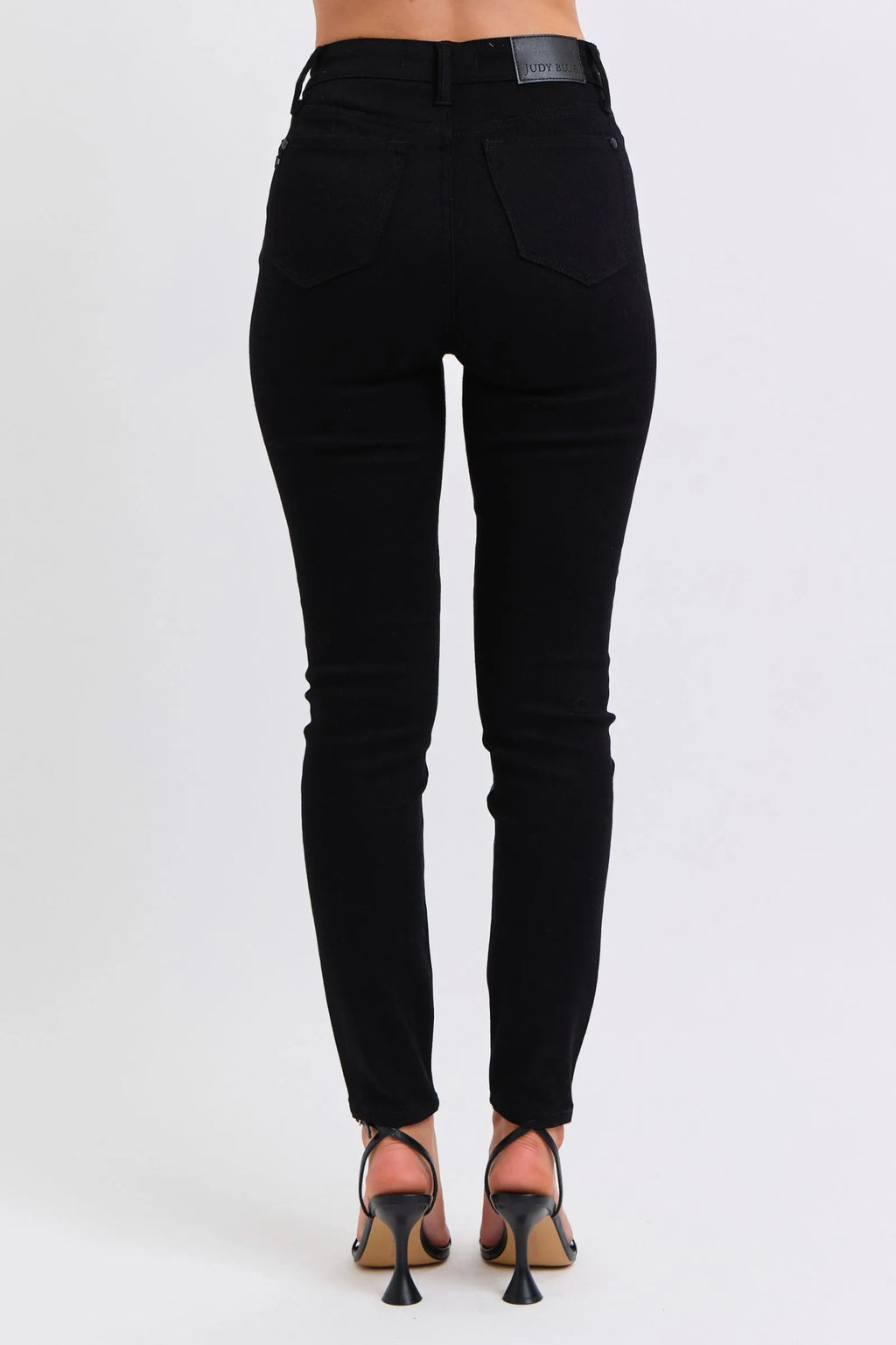 Black faux leather skinny pants, full back view with belt loops and button closure