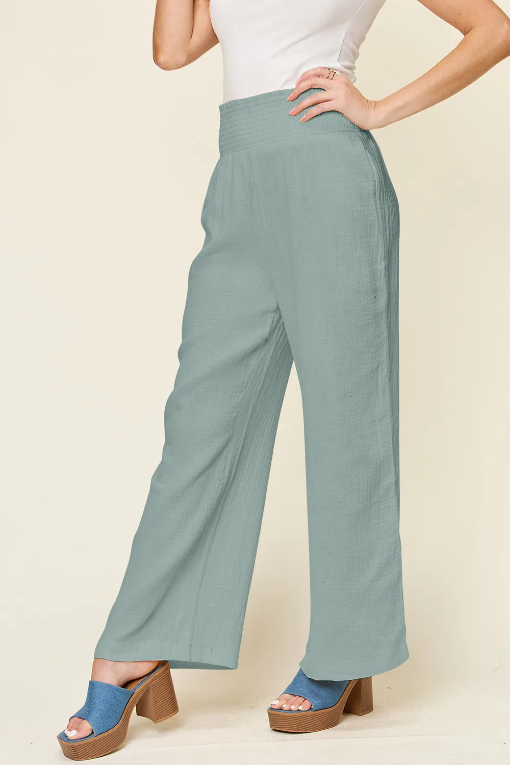 Teal textured wide-leg pants with smocked waistband, full-length side view
