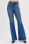High-rise flare jeans in dark wash blue denim with distressed patches and button fly.
