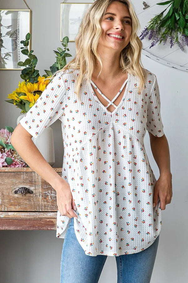 White ditsy floral babydoll top with crisscross V neckline and relaxed fit