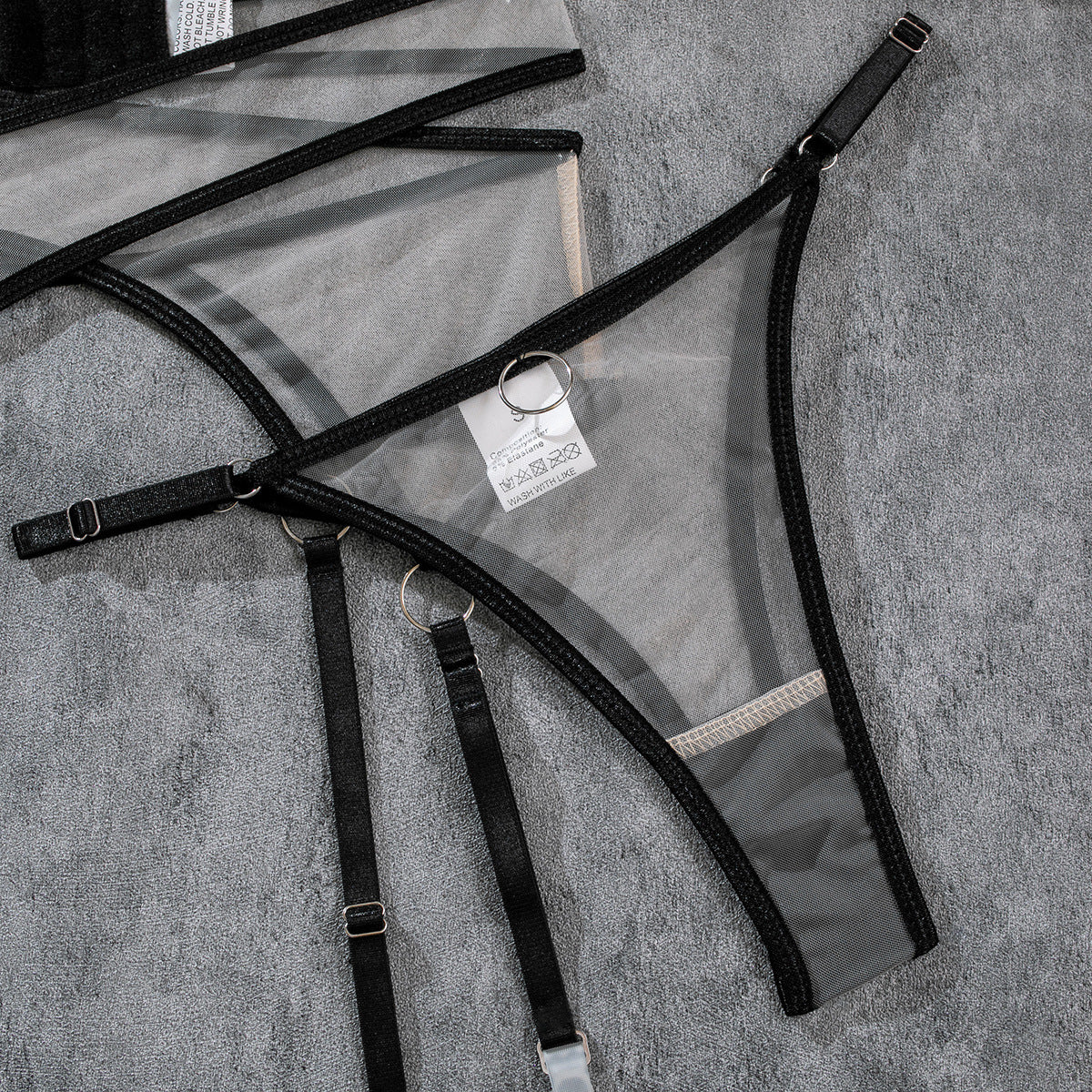 Black mesh underwear straps and garter pieces with metal rings and buckles