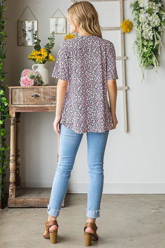 Back view of ivory animal-print babydoll top with short sleeves and crisscross neckline