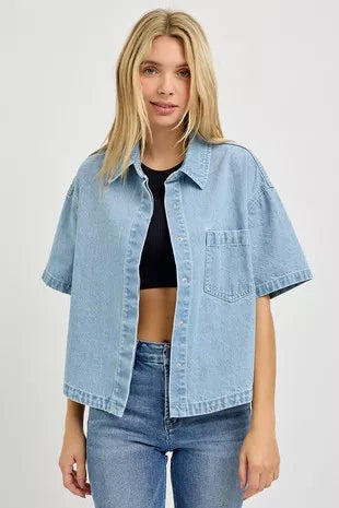 Light-wash oversized cropped denim shirt over black top, collar and chest pocket visible