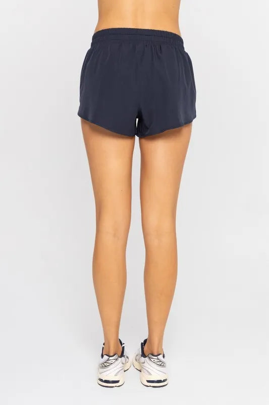 Navy drawcord mini shorts with elastic waistband, back view