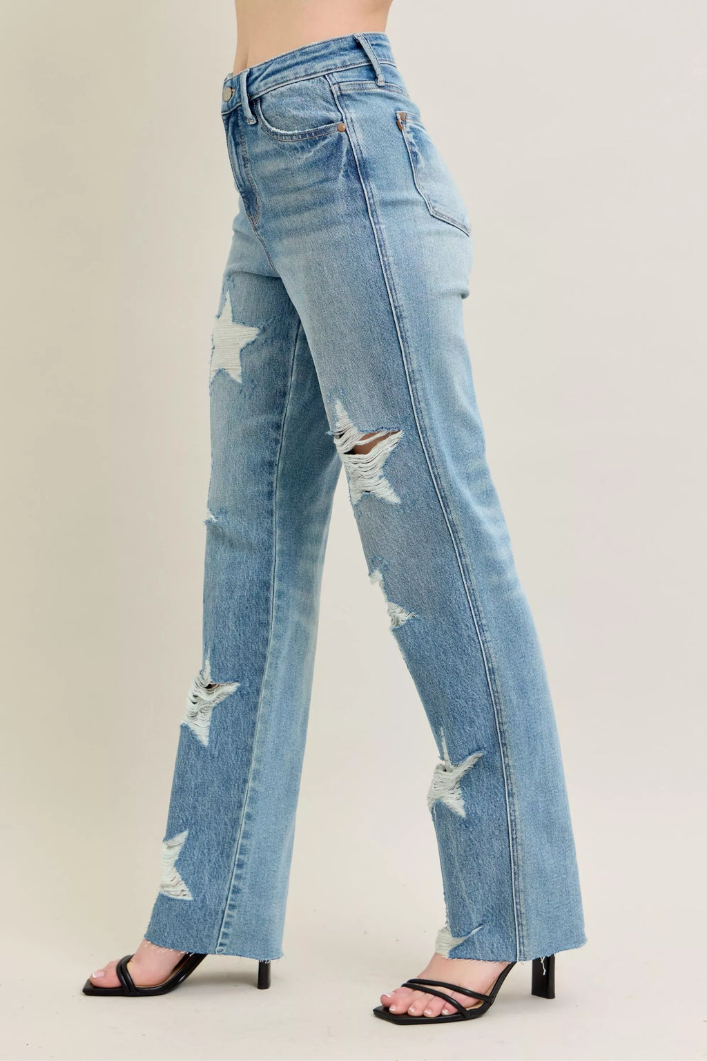 Leg side view: light wash straight jeans with star rips along the thigh