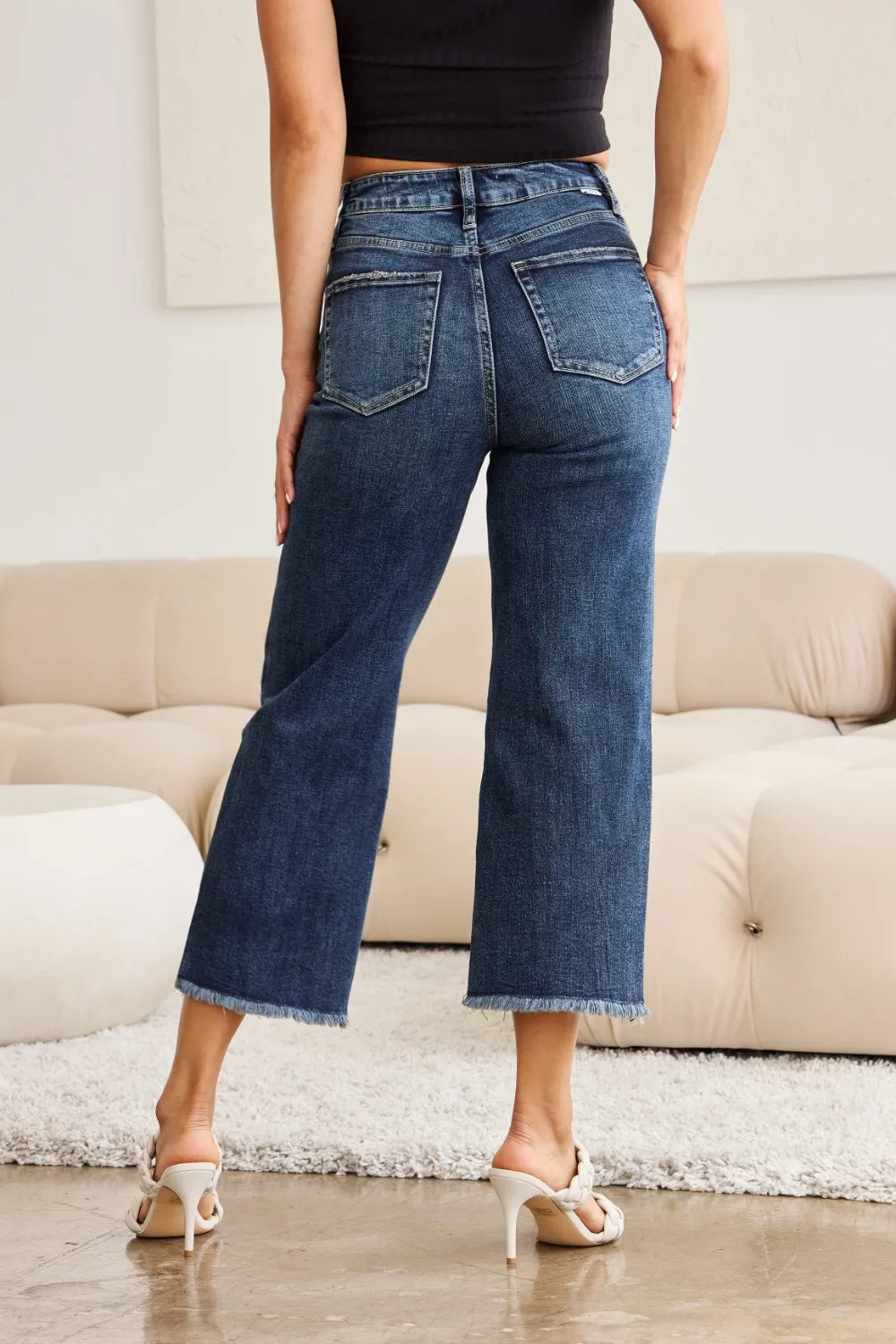 Back view high-waist dark-wash jeans with patch pockets and raw cuff hem